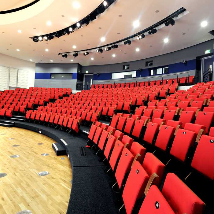 The Eastern Gateway auditorium at Brunel University London, tiered red seating facing a presentation floor